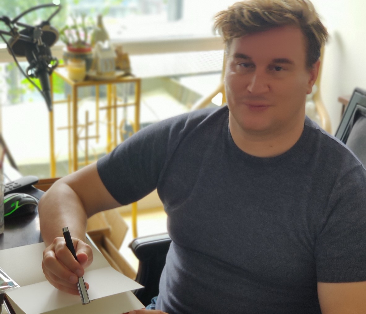 Alexander Paul Burton writing at his studio desk